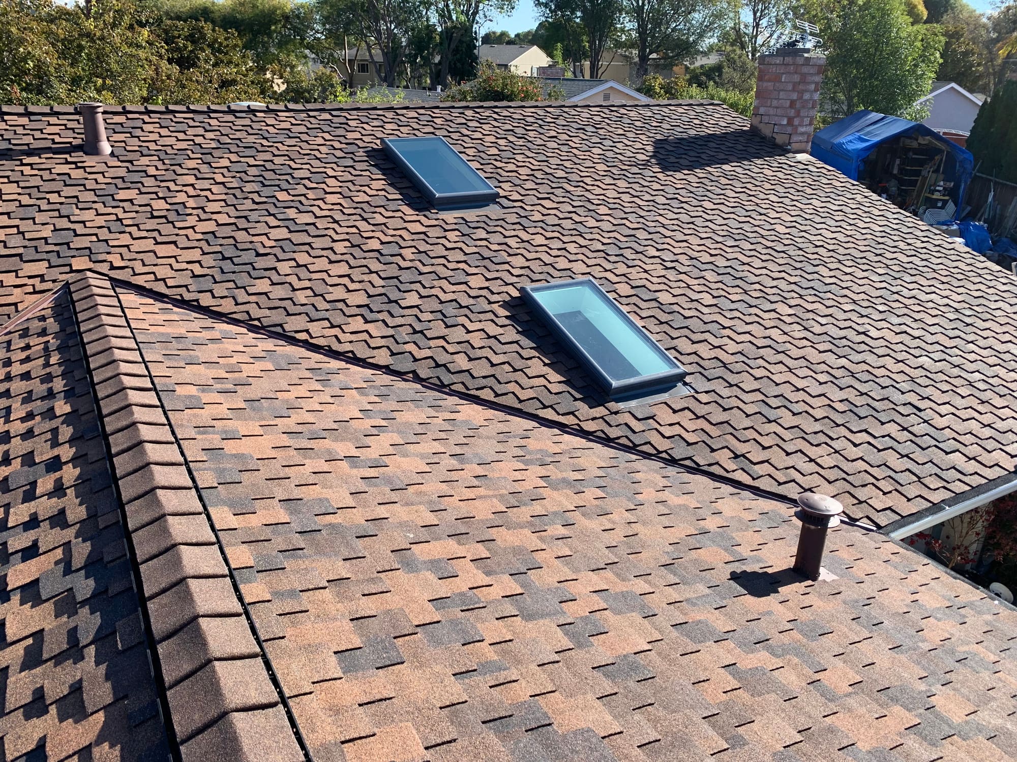Close-up of a finished Malarkey-style shingle roof with skylights